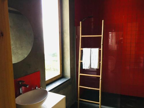a bathroom with a sink and a ladder next to a window at Casa das Artes in Serreta