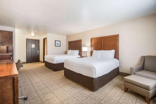 a hotel room with two beds and a chair at Comfort Inn Newport in Newport