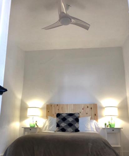 a bedroom with a ceiling fan and two lamps at Damajuana in Níjar
