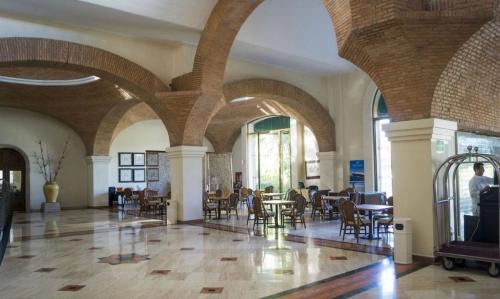 a lobby with tables and chairs in a building at Velas Vallarta Condo in Puerto Vallarta