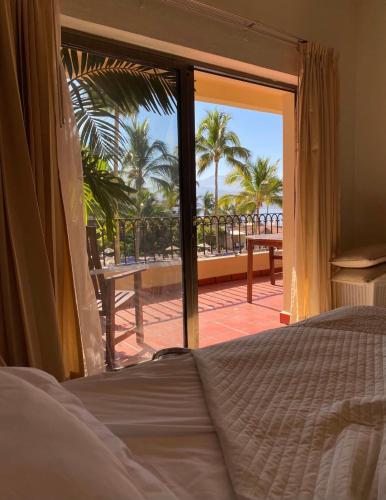 a bedroom with a bed and a view of the beach at Velas Vallarta Condo in Puerto Vallarta