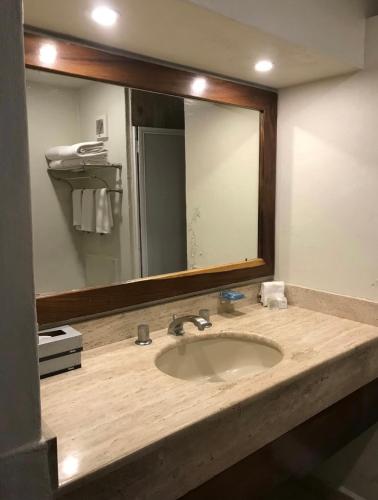 a bathroom with a sink and a large mirror at Velas Vallarta Condo in Puerto Vallarta