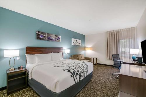 a hotel room with a bed and a television at Sleep Inn in Clovis