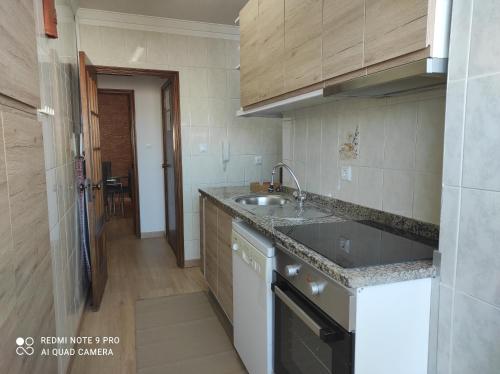eine Küche mit einer Spüle und einer Arbeitsplatte in der Unterkunft Apartamento S. João da Foz in Porto