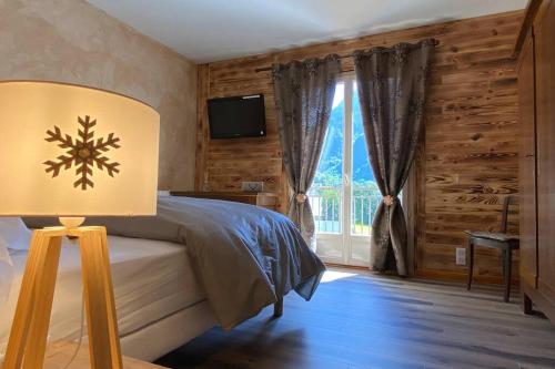 une chambre avec un lit avec une lampe et une fenêtre dans l'établissement Vaste T4 115m2. Balcon. Vue. Suite. Jardin et jeux, à Cauterets