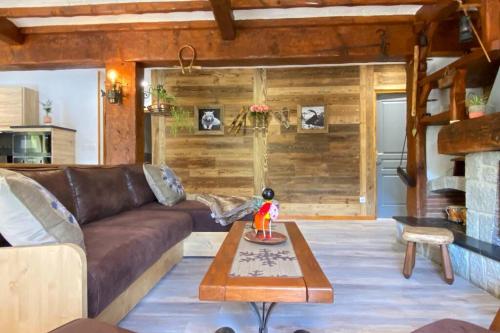un salon avec un canapé marron et une table dans l'établissement Vaste T4 115m2. Balcon. Vue. Suite. Jardin et jeux, à Cauterets