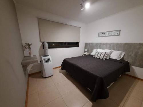 a bedroom with a bed in a white room at Departamentos René in Ciudad Lujan de Cuyo