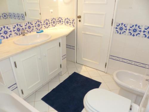 a bathroom with a white sink and a toilet at Ocean facing at Senhora da Rocha in Porches