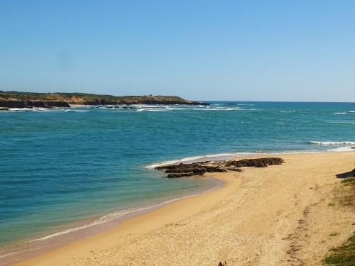 a beach with the ocean and the shoreline at MIRA VILA by Stay in Alentejo for HIKERS in Vila Nova de Milfontes