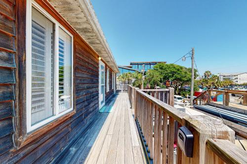 a wooden balcony of a house with a window at Folly Beach Condos in Folly Beach