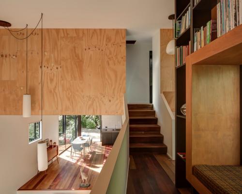 a room with a staircase and a living room at Blackpool House - Stay Waiheke in Oneroa