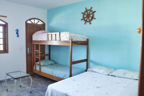 1 dormitorio con 2 literas y pared azul en Apartamento Beira Mar en Pontal do Paraná