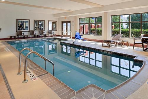 a large swimming pool with blue water in a building at Baymont by Wyndham Bessemer in Bessemer