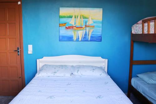 a bedroom with a bed and a painting of boats at Apto Frente para o Mar in Pontal do Paraná