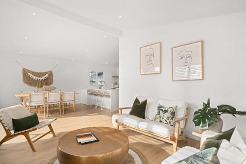 a living room with a couch and a table at Stay Mission Bay in Auckland