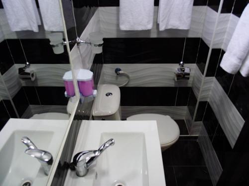 a small bathroom with a sink and a toilet at City Apartments in Eilat