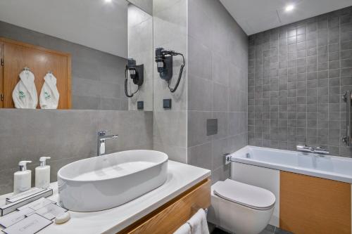 a bathroom with a tub and a toilet and a sink at Holiday Inn Yerevan - Republic Square by IHG in Yerevan