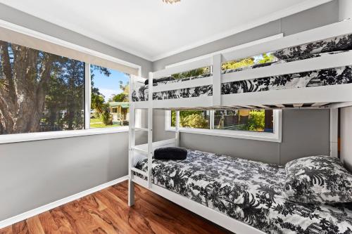 a bedroom with bunk beds and a window at Flynns Beach Caravan Park in Port Macquarie