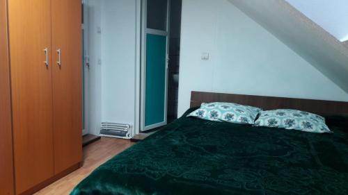 - une chambre avec un lit vert et 2 oreillers dans l'établissement Family&Friends, à Ceahlău