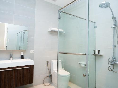 a bathroom with a shower and a toilet and a sink at City Park Hotel Residences in Manila