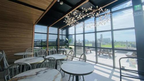 un restaurante con mesas y sillas y una gran ventana en Hotel Lounge, en Toucheng