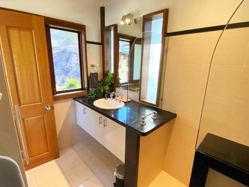 新月岬The Pool House - Crescent Head - stunning ocean views, pet friendly的带水槽和镜子的浴室
