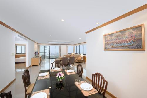 a dining room with tables and chairs and a painting on the wall at Riverine Place Hotel and Residence in Nonthaburi