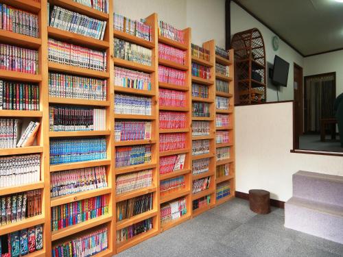 a library with wooden shelves filled with books at Pension Kobekko in Otari