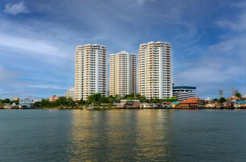 dwa wysokie budynki na brzegu wody w obiekcie Riverine Place Hotel and Residence w mieście Nonthaburi
