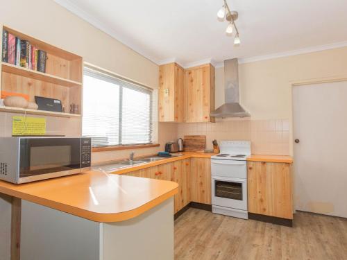 a kitchen with wooden cabinets and a counter top at Charvel 2 35 Gippsland Street in Jindabyne