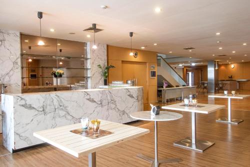 a restaurant with three tables and a counter at Riverine Place Hotel and Residence in Nonthaburi