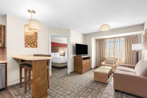 a hotel room with a bed and a living room at Staybridge Suites - Orenco Station by IHG in Hillsboro