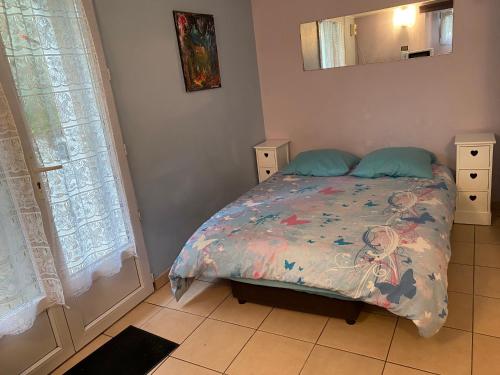- une chambre avec un lit et une couette colorée dans l'établissement Charmant Studio Équipé Proche Paris et Versailles, à Chaville