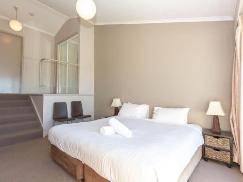 a bedroom with a large white bed with two pillows at Horizons 219/10 Kosciuszko Road in Jindabyne