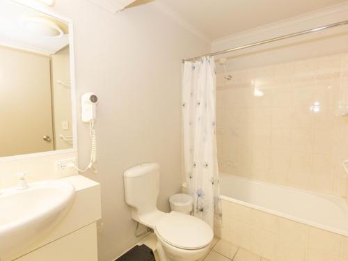 a white bathroom with a toilet and a sink at Horizons 219/10 Kosciuszko Road in Jindabyne