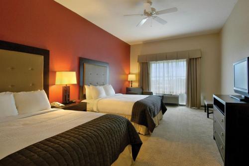 a hotel room with two beds and a flat screen tv at Holiday Inn Hotels Batesville, an IHG Hotel in Batesville