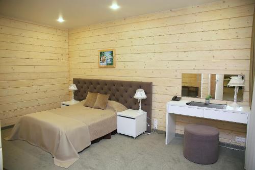 a bedroom with a bed and a desk and a mirror at Chayka Resort in Odesa