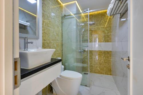 La salle de bains est pourvue de toilettes, d'un lavabo et d'une douche. dans l'établissement Căn hộ Quận 4 GoldView Aparment, à Hô-Chi-Minh-Ville