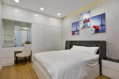 - une chambre avec un lit et un bureau avec une chaise dans l'établissement Căn hộ Quận 4 GoldView Aparment, à Hô-Chi-Minh-Ville