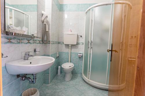 a bathroom with a sink and a toilet and a shower at Residence & Suites in Bellaria-Igea Marina