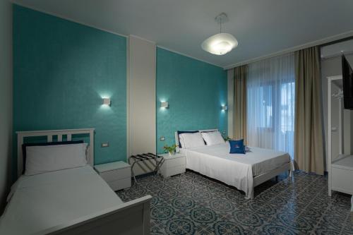 a hotel room with two beds and a window at The Reef in Sorrento
