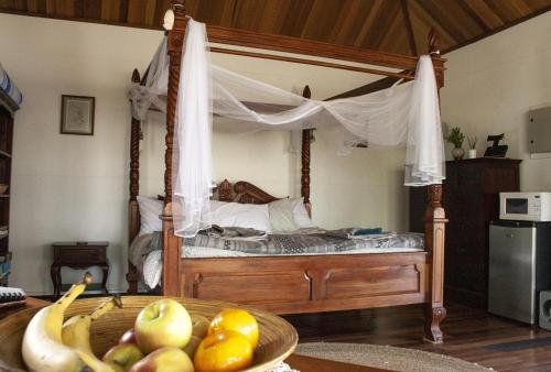 a bedroom with a canopy bed with a bowl of fruit at Barrabup Sanctuary BirdHide in Nannup