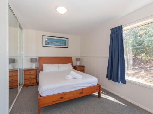 a bedroom with a bed and a window at Torino 2 14 Nettin Circuit in Jindabyne