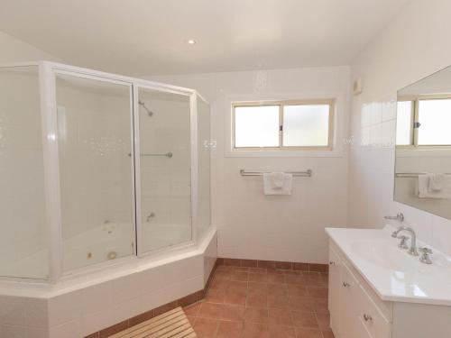 a bathroom with a shower and a tub and a sink at Torino 2 14 Nettin Circuit in Jindabyne
