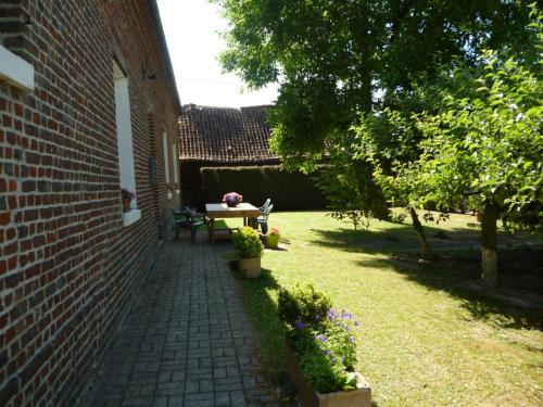 a patio with a table and a bench in a yard at Charmant appartement à la ferme, 2 chambres, Wi-Fi, proche Auxi-le-Château - FR-1-376-28 in Wavans