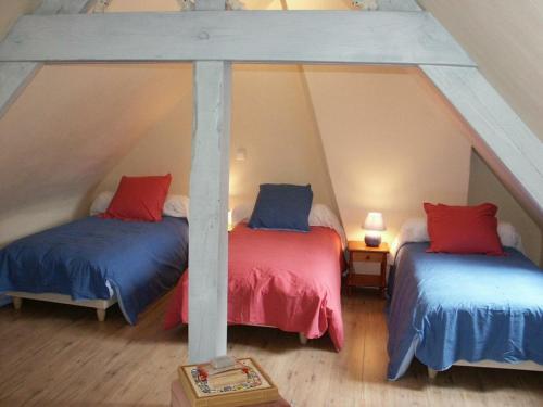 ブレレにあるGîte Bléré, 5 pièces, 10 personnes - FR-1-381-6の屋根裏部屋(青と赤の枕が備わるベッド2台付)