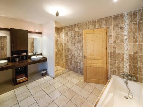 uma casa de banho com uma banheira e um lavatório em Gîte Montarcher, 4 pièces, 6 personnes - FR-1-496-11 em Montarcher