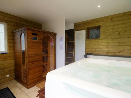 uma grande banheira num quarto com paredes de madeira em Studio Saint-André-d'Apchon, 1 pièce, 2 personnes - FR-1-496-23 em Saint-André-dʼApchon
