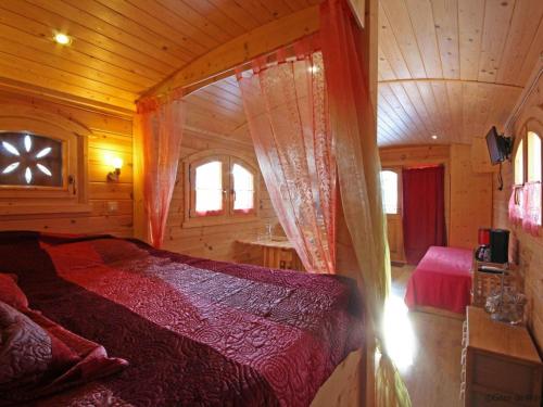 a bedroom with a bed in a wooden cabin at Gîte Radon, 2 pièces, 3 personnes - FR-1-497-130 in Radon