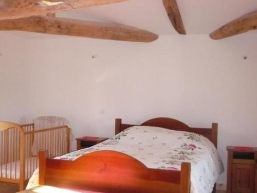 ein Schlafzimmer mit einem Bett mit einem Holzrahmen in der Unterkunft Gîte Saint-Georges-de-Baroille, 4 pièces, 6 personnes - FR-1-496-170 in Saint-Georges-de-Baroille